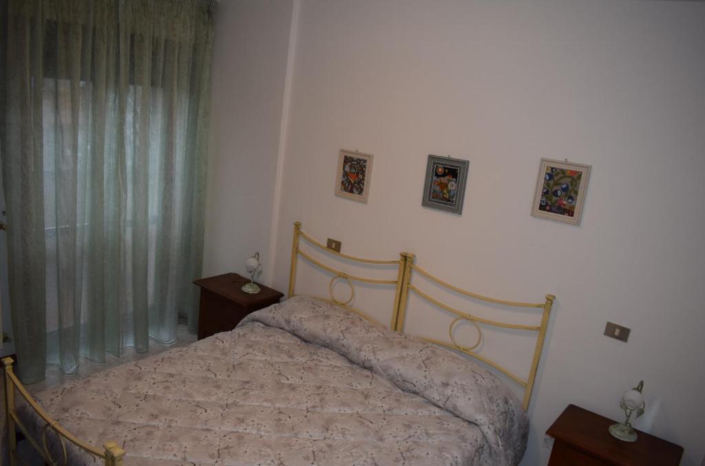 1 dormitorio con 1 cama y 2 cuadros en la pared en La Ninfea, en Pisa