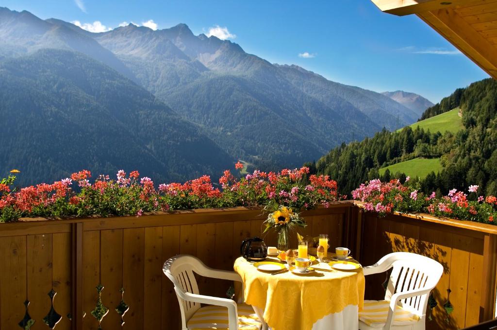 a table on a balcony with a view of mountains at Ferienwohnungen Zeppenhof in Santa Valpurga