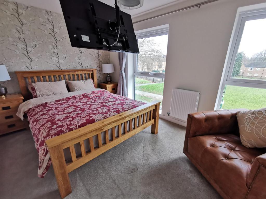 a bedroom with a large bed and a couch at Helena's Place (7 minutes walk to Nottingham Train station) in Nottingham