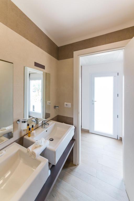 a bathroom with two sinks and a large mirror at Torre Cintola Greenblu Sea Emotions in Monopoli