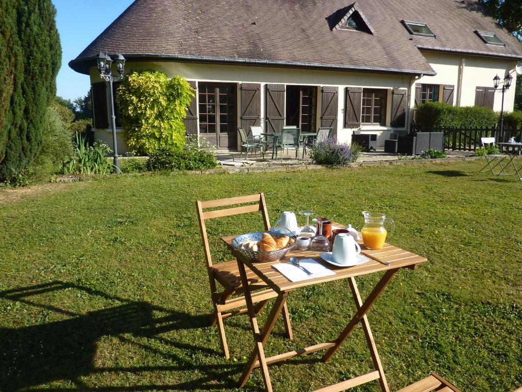 - une table avec un bol de nourriture dans la cour dans l'établissement Demeure de charme en Normandie, à Canehan