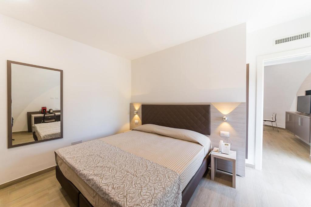 a bedroom with a large bed and a mirror at Torre Cintola Greenblu Sea Emotions in Monopoli