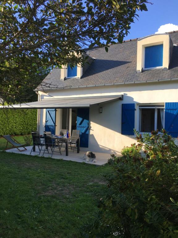 Cette maison dispose de portes bleues et d'une table de pique-nique sur une terrasse. dans l'établissement Domaine de Praline maison de Fouesnant, à Fouesnant