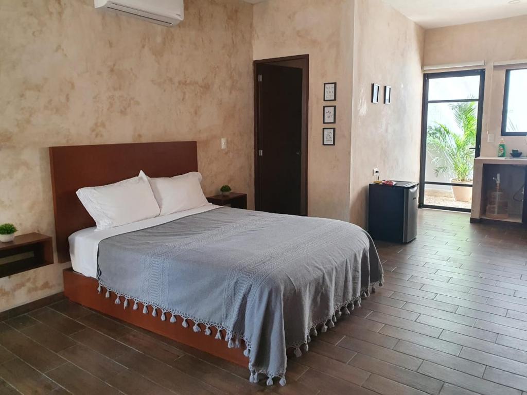 um quarto com uma cama grande num quarto em Hotelito YUM KAAX em Mérida