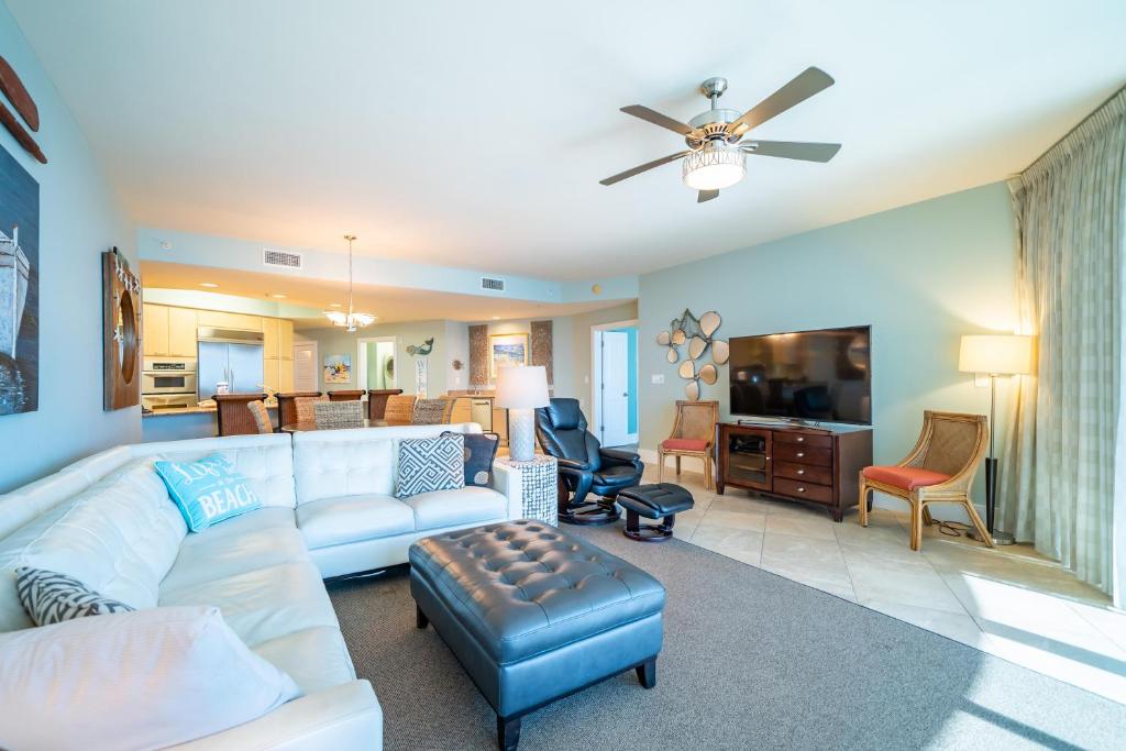 uma sala de estar com um sofá branco e uma televisão em Caribe Unit D514 em Orange Beach