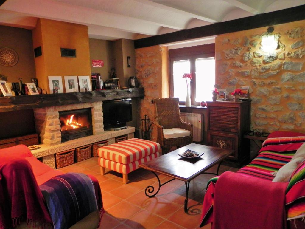 uma sala de estar com um sofá e uma lareira em Casa Rural " LA PARRA" em Peralejos de las Truchas