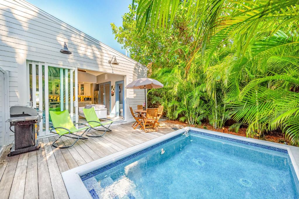 a swimming pool on a deck next to a house at Tropical Vibes in Key West