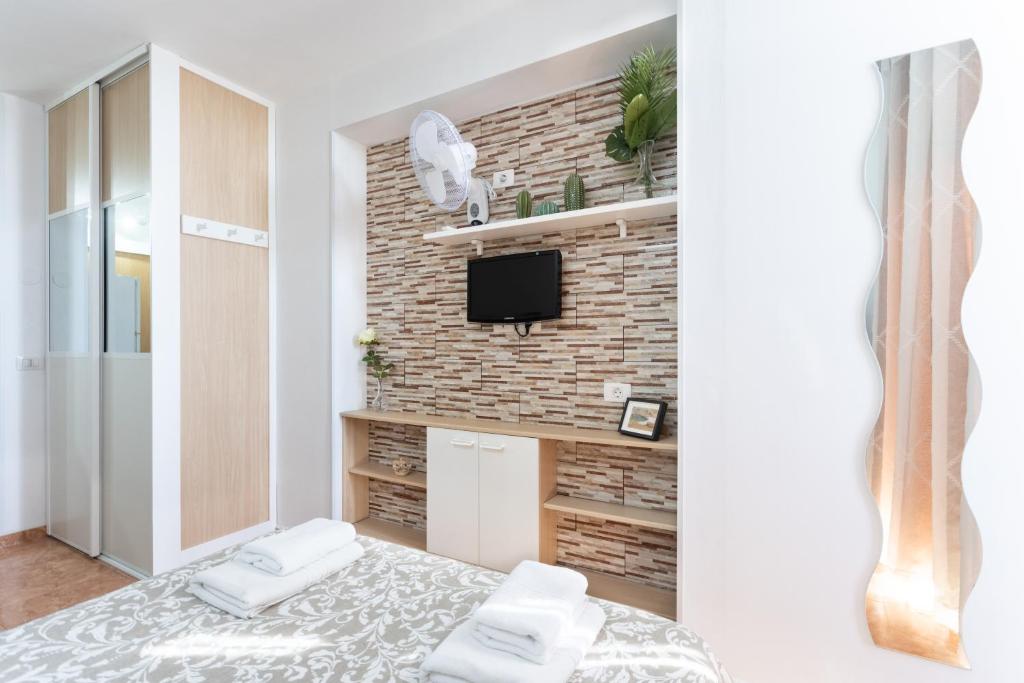 a living room with a tv and a brick wall at Apartamentos Ohana - Edificio Tonillo in Los Cristianos
