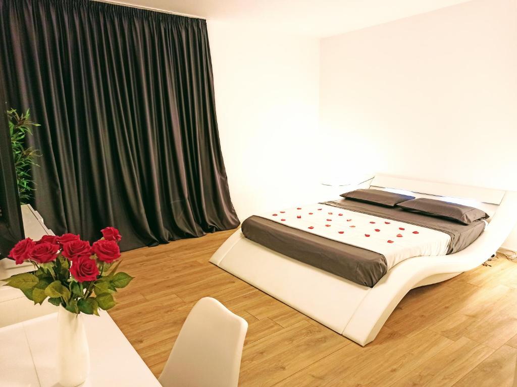 una camera da letto con un letto e un vaso di rose rosse di Guest House - La bella vita a Orosei