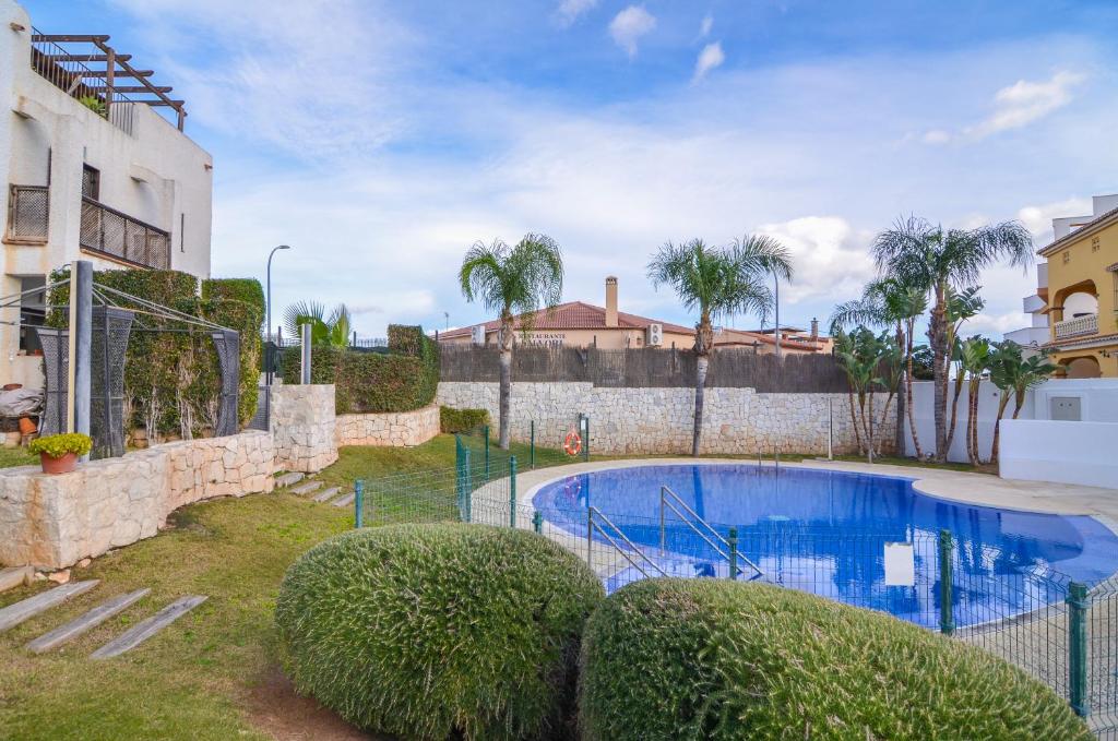 basen w ogrodzie obok budynku w obiekcie WintowinRentals Townhouse, Roof Terraze & Pool w mieście Torre de Benagalbón