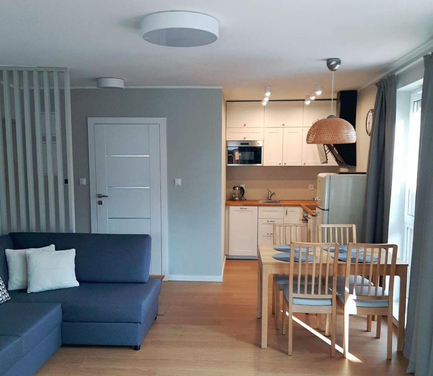 uma sala de estar com um sofá azul e uma mesa em Apartament Rodzinny em Szklarska Poręba