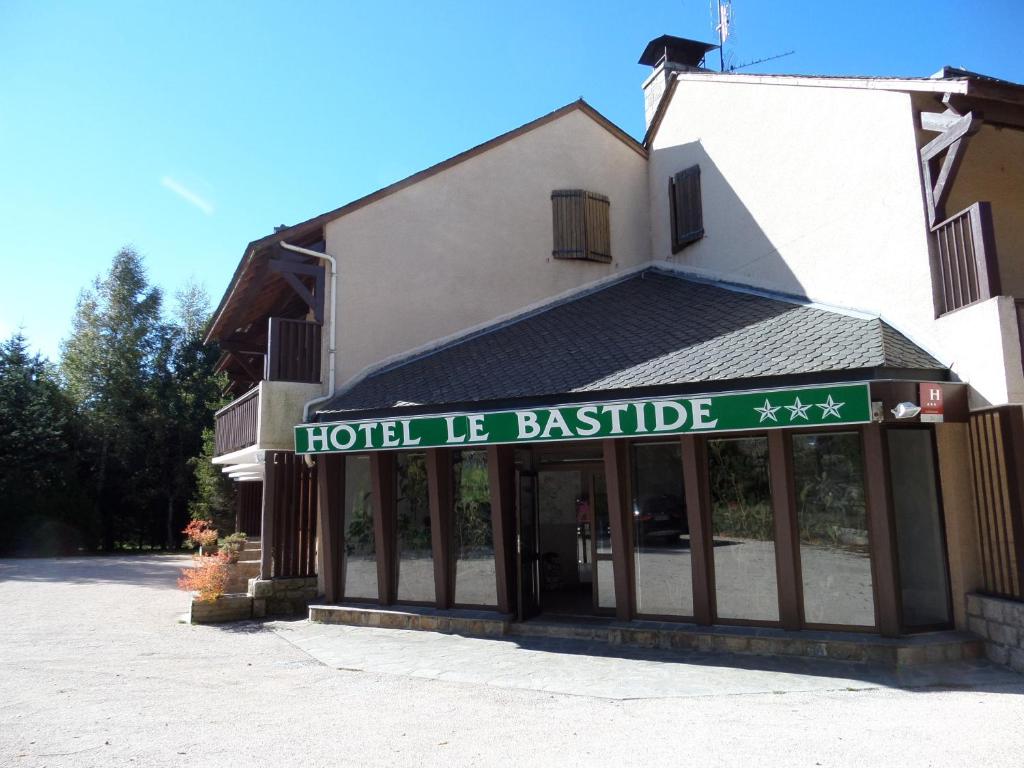 um sinal de hotel la bastille na frente de um edifício em Hôtel le bastide em Nasbinals