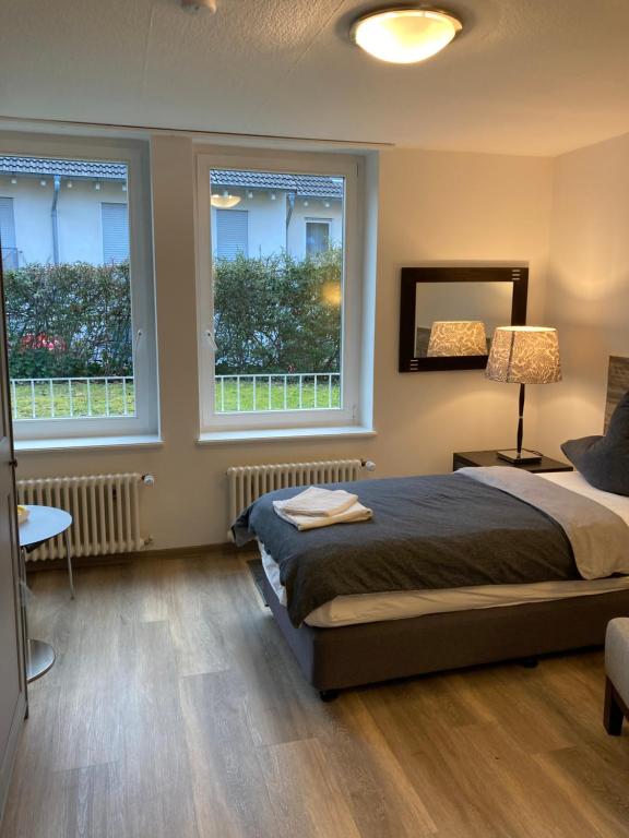 a bedroom with a bed and two windows at Haus Berlin in Hagen