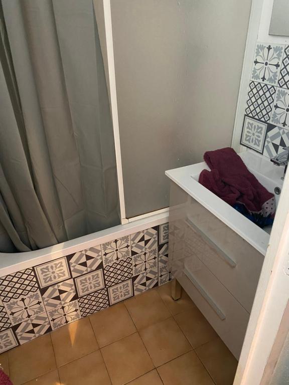 La salle de bains est pourvue d'une douche avec rideau de douche. dans l'établissement Studio Residence Le Stella, à Ancelle