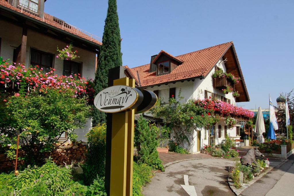 a sign in front of a house with flowers at Hotel Neumayr in Munich