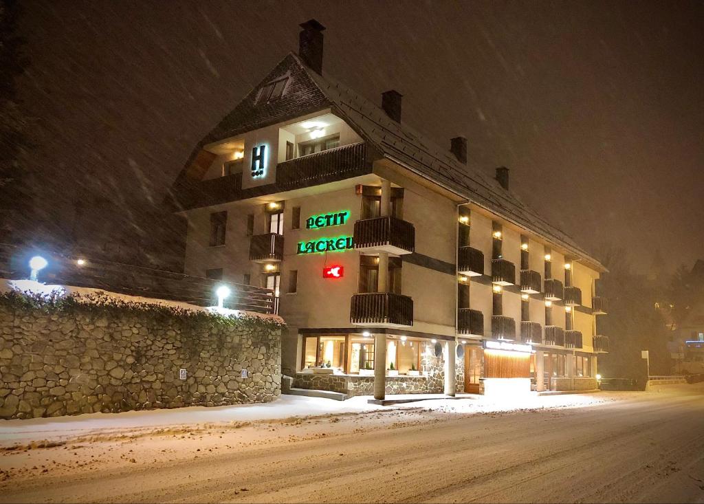 a hotel in the snow at night at Hotel Petit Lacreu in Salardú