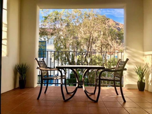 einen Tisch und zwei Stühle vor einem Balkon in der Unterkunft Beautiful Casita, La Quinta Legacy Villas Resort in La Quinta