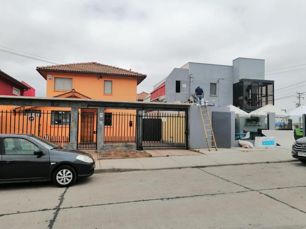 un coche aparcado en un estacionamiento frente a una casa en Hospedaje casa Arrayan en La Serena