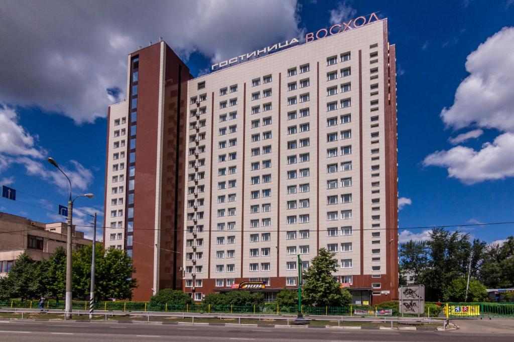 a large white building with a sign on it at Апартаменты Восход in Moscow