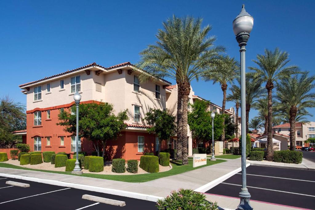 a street light in front of a building with palm trees at Sonesta Simply Suites Phoenix Scottsdale in Scottsdale