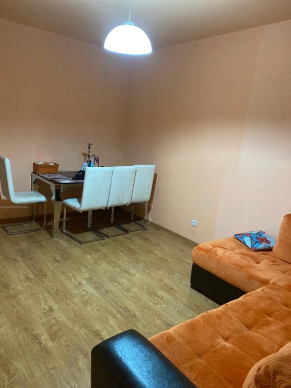 a room with a desk and a table and a couch at Апартамент in Varna City