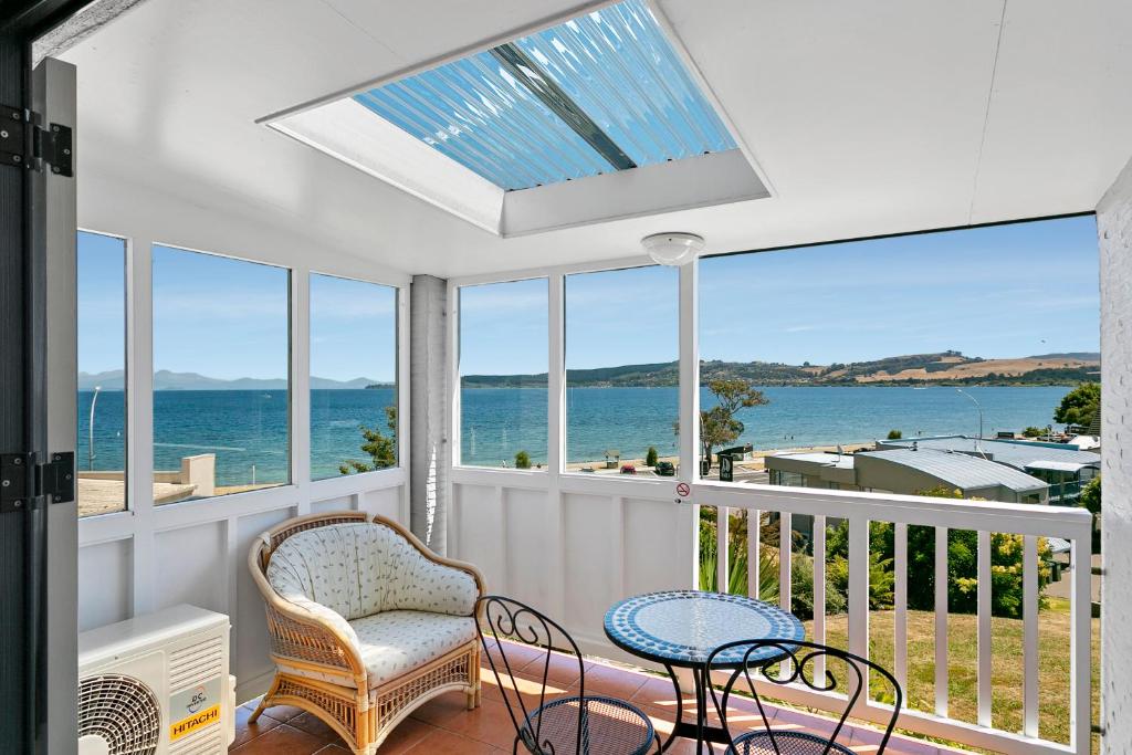Habitación con balcón con vistas al océano. en Baycrest Thermal Lodge, en Taupo