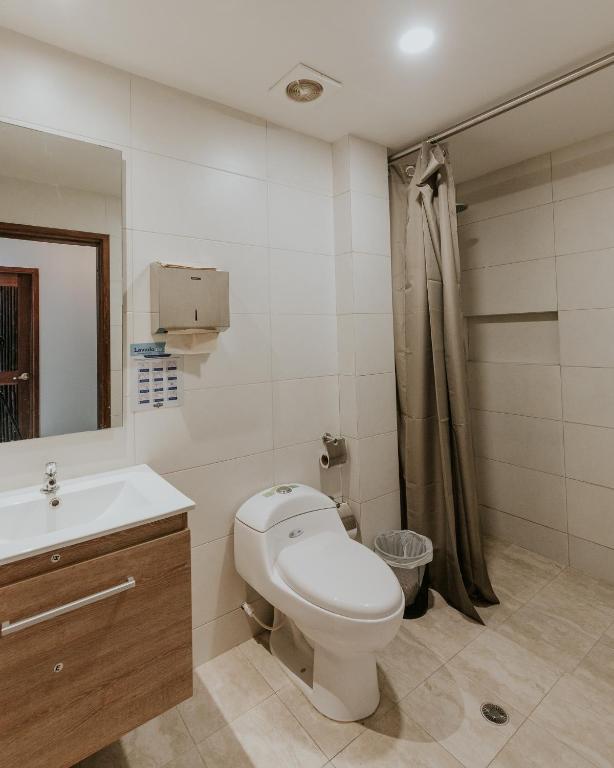 a bathroom with a toilet and a sink and a shower at Distrito Hostel in Santa Marta
