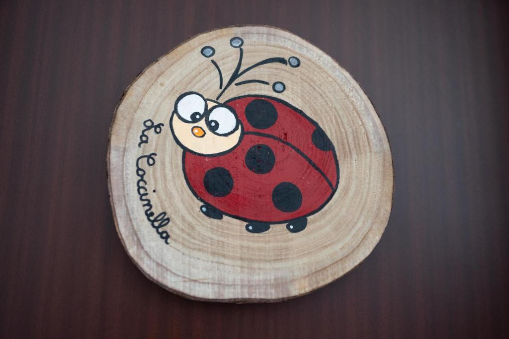 a drawing of a ladybug on a wooden plate at La nuova Coccinella in Bra