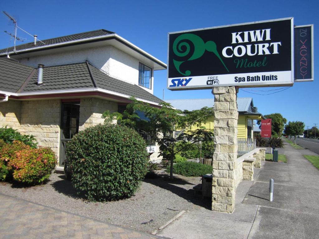 um sinal de motel kiwi Court em frente a uma casa em Kiwi Court Motel em Hawera