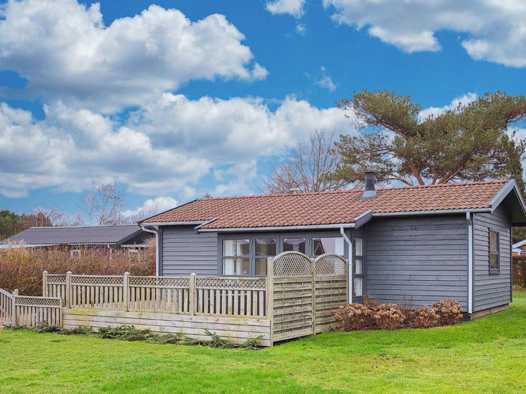 a house with a wooden fence in a yard at 4 person holiday home in Svendborg in Svendborg