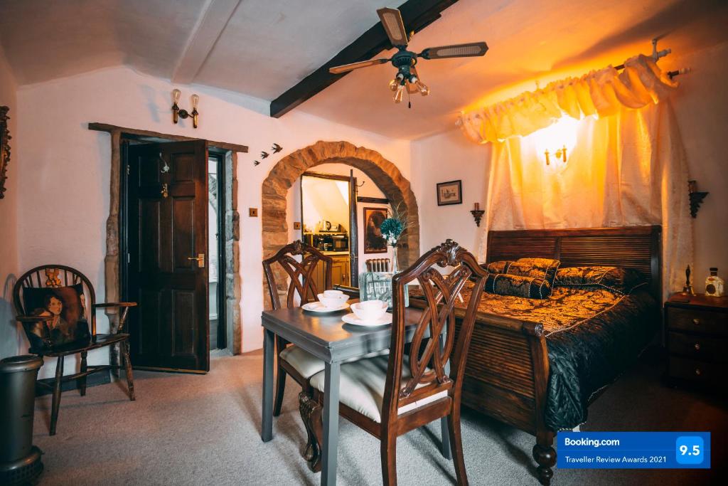 Schlafzimmer mit einem Bett, einem Tisch und einem Deckenventilator in der Unterkunft The Rookery Nook and Brontë Parsonage - Haworth in Haworth