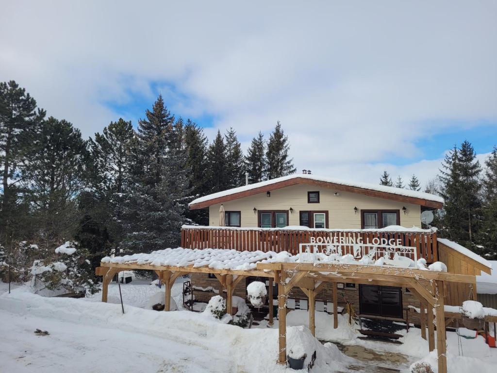 ein Haus im Schnee mit Schnee auf dem Deck in der Unterkunft Whispering Pines Suite at The Bowering Lodge in Blue Mountains