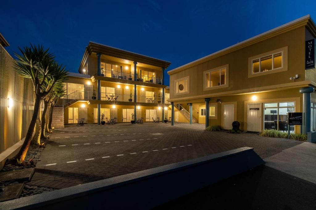 an empty parking lot in front of a building at night at Motel de la Mer in Napier