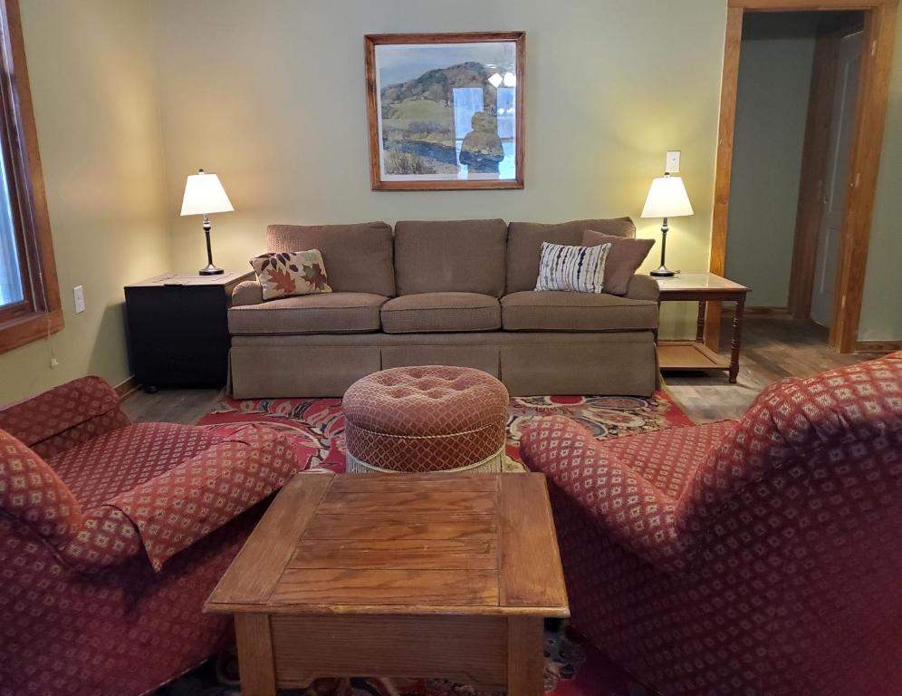 een woonkamer met een bank en 2 stoelen bij The Cabins at Healing Springs in Crumpler