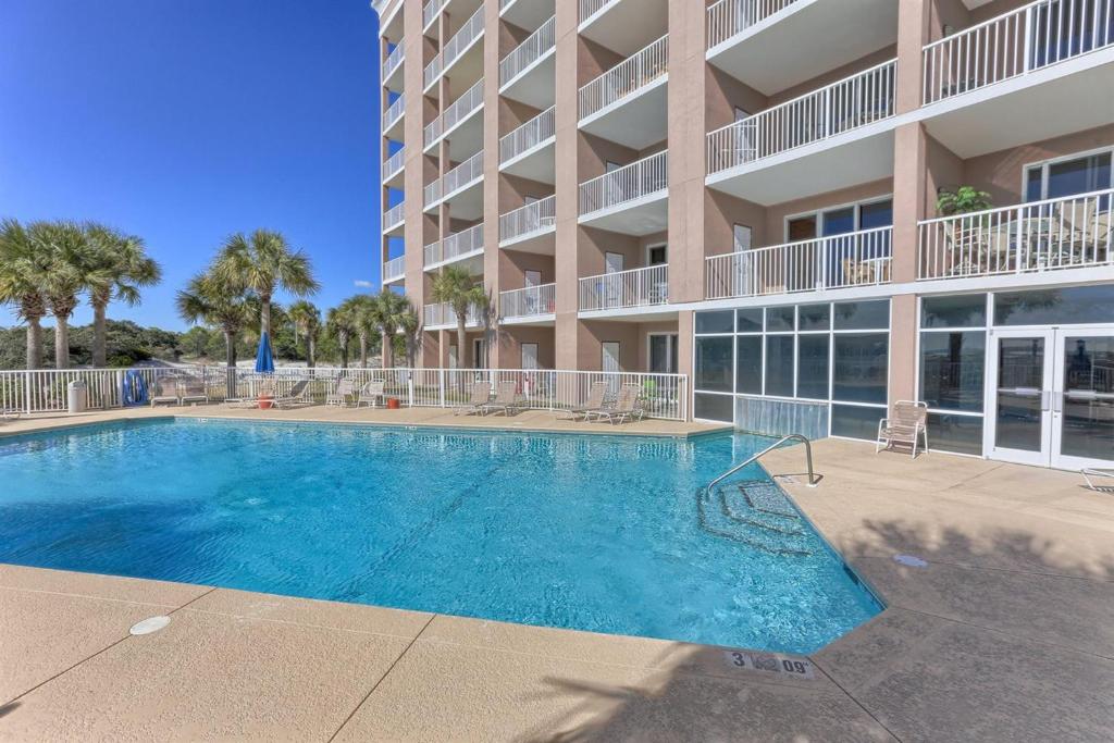 a swimming pool in front of a apartment building at The Dunes in Gulf Shores