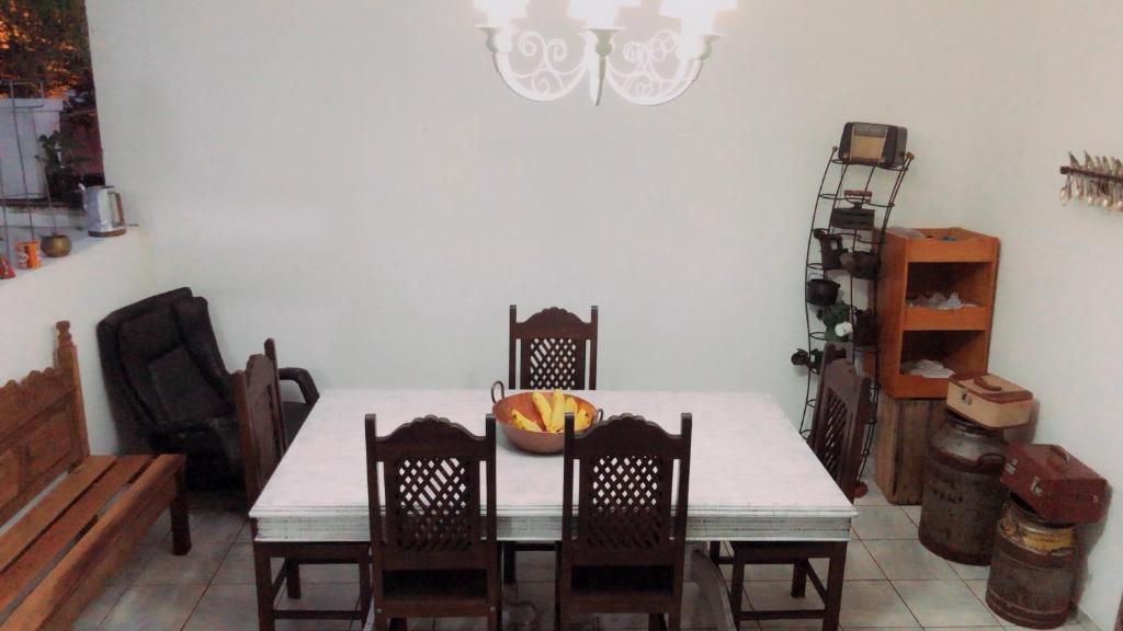 Hostel Tropeiro de Minas في جويز دي فورا: طاولة غرفة الطعام مع وعاء من الفواكه عليها