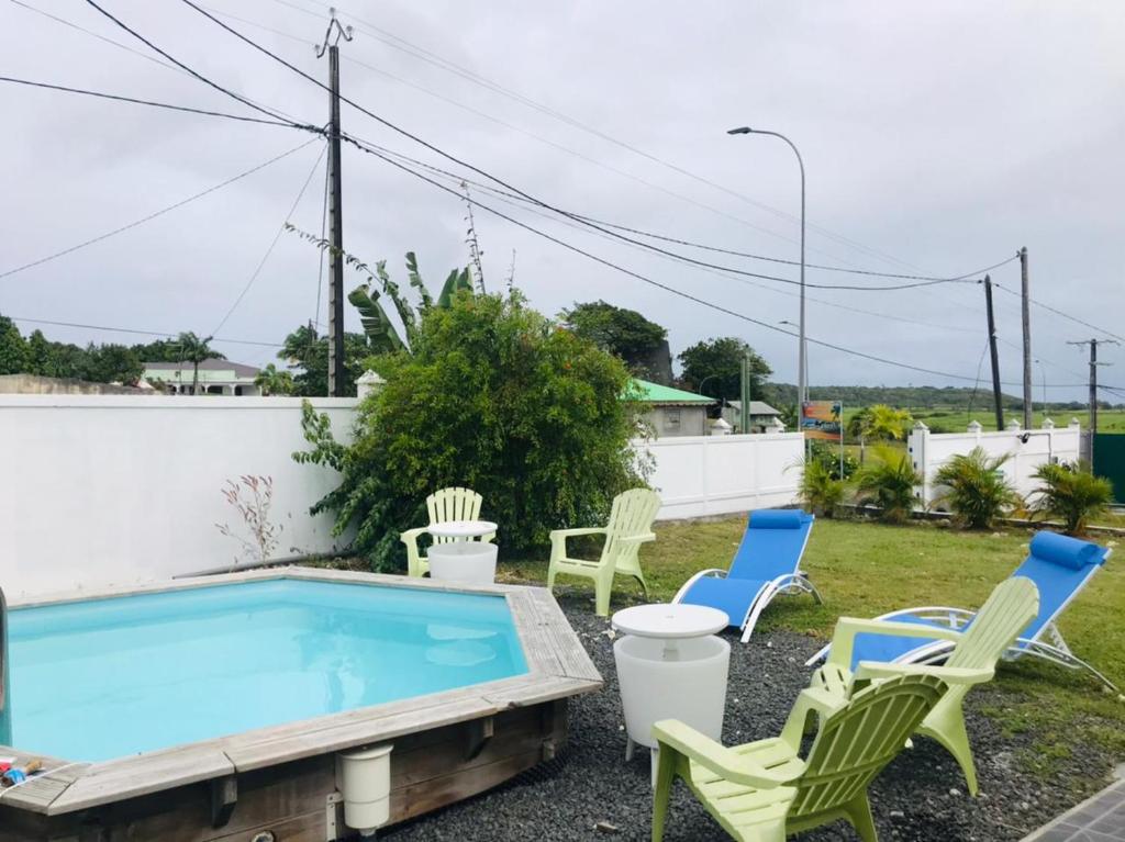 a patio with chairs and a swimming pool at Tropic Arth Paradise in Port-Louis