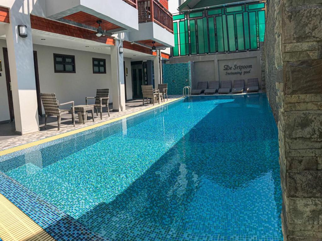 a swimming pool with blue water in a building at Hotel De Sripoom in Chiang Mai