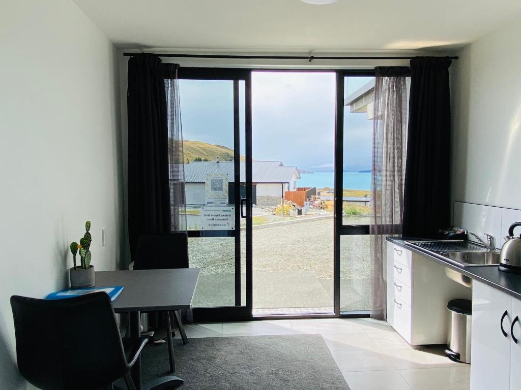 a kitchen with a table and a view of the ocean at GALAXY LAKE VIEW STUDIO in Lake Tekapo