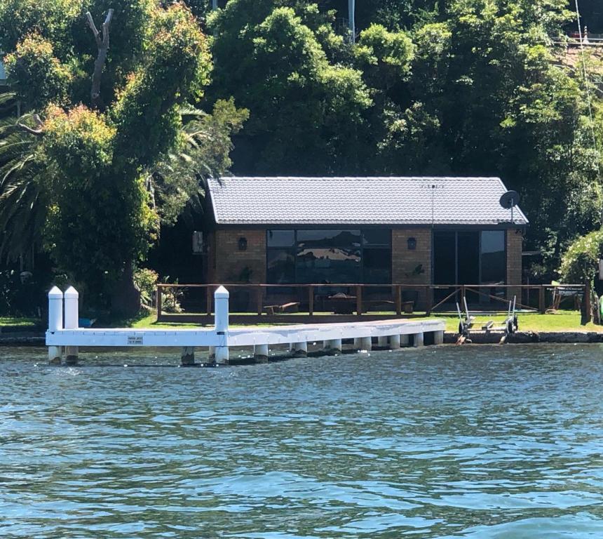 a house on the shore of a body of water at Serenity by the Lake - Romantic Waterfront Couple's Getaway in Marks Point