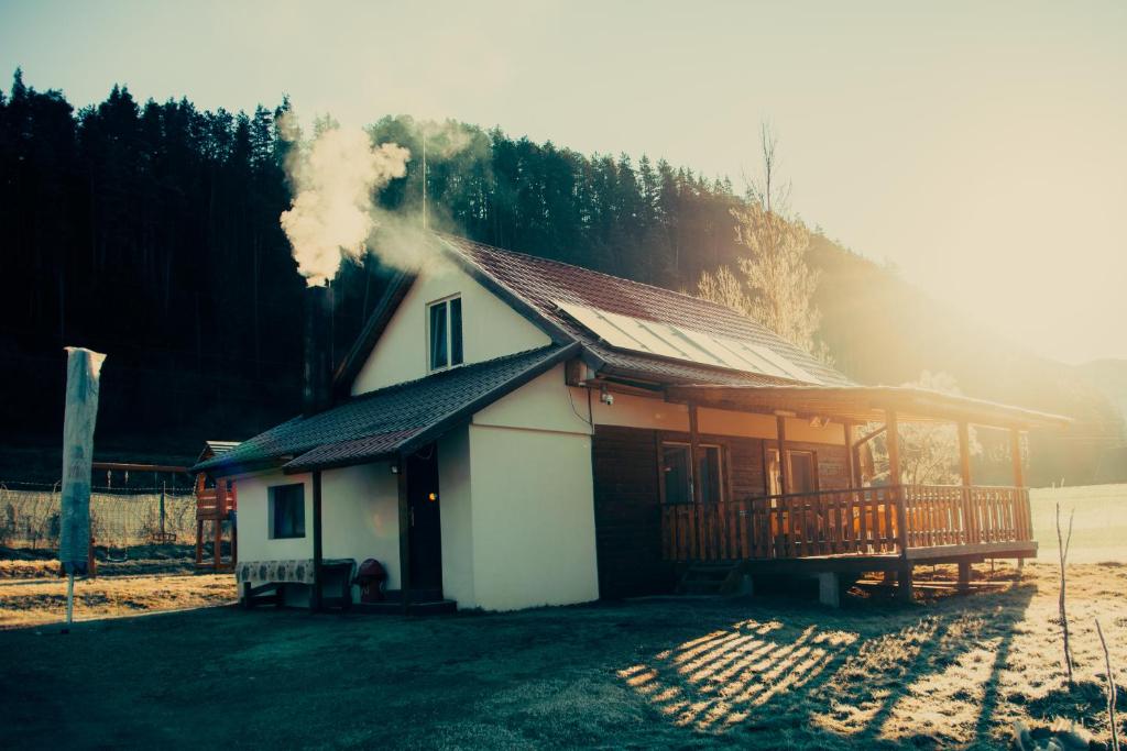 Une petite maison avec de la fumée qui en sort dans l'établissement Cabana Săcuieu Vlădeasa, à Săcuieu