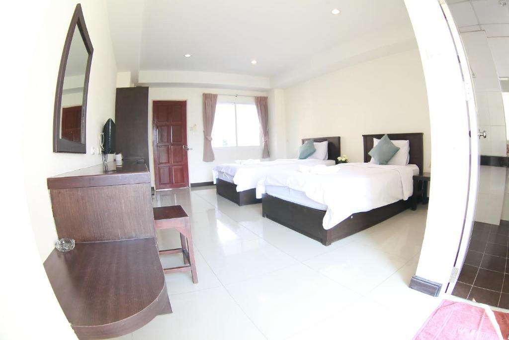 a large bedroom with two beds and a mirror at วีรวรรณ เพลส Weerawan Place in Khon Kaen