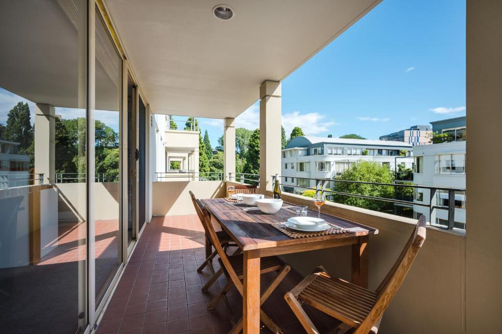 balcón con mesa y sillas de madera en Jenatt Apartments Salamanca, en Hobart