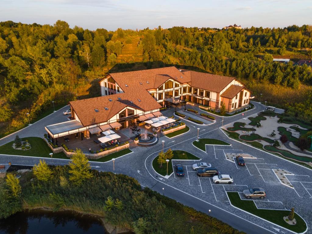 an aerial view of a large house with a parking lot at Equides club in Lesniki