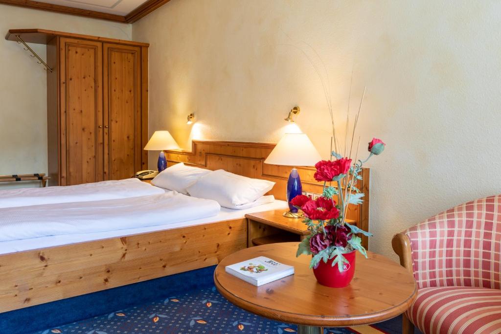 a hotel room with a bed and a table and a couch at Sackmann Wanderhotel in Baiersbronn