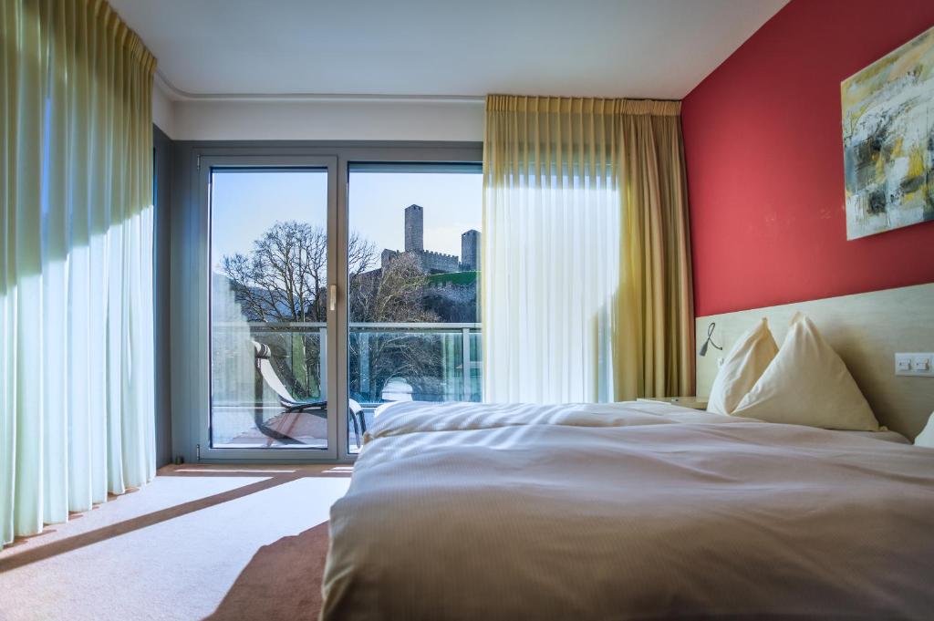 a bedroom with a bed and a large window at Hotel Unione in Bellinzona