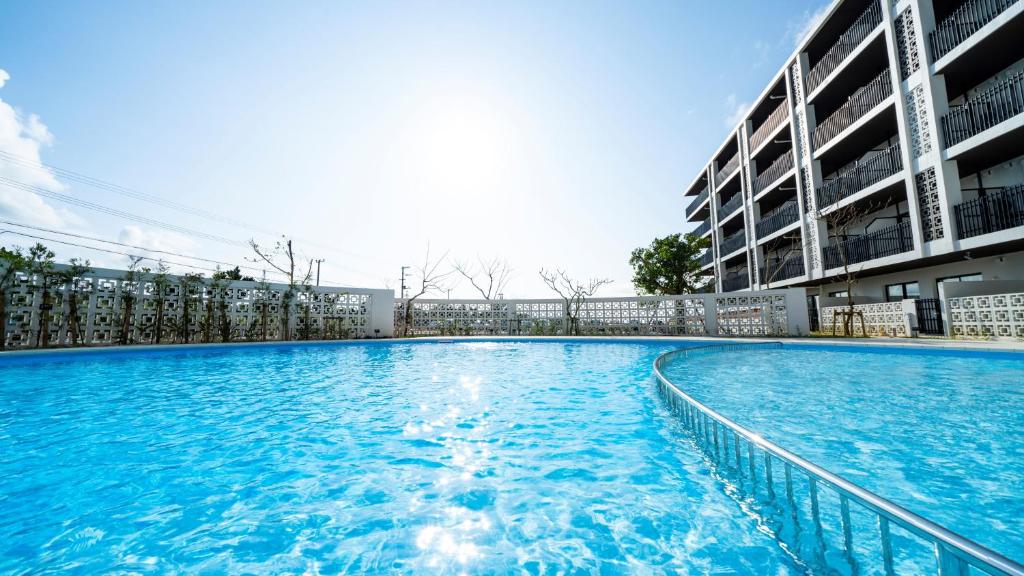 a large swimming pool in front of a building at Hotel Torifito Miyakojima Resort in Miyako-jima