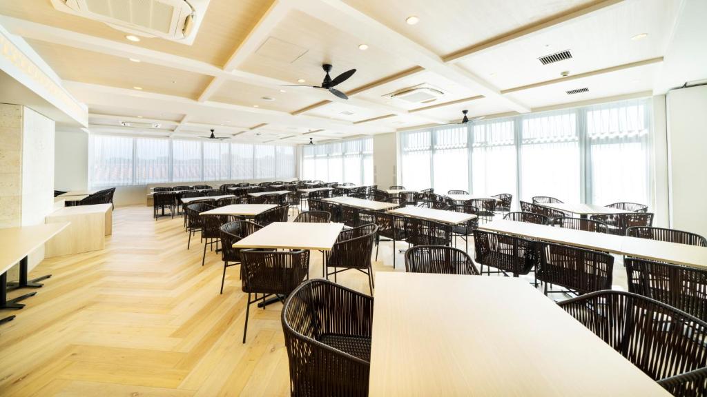 an empty dining room with tables and chairs at Hotel Torifito Miyakojima Resort in Miyako-jima