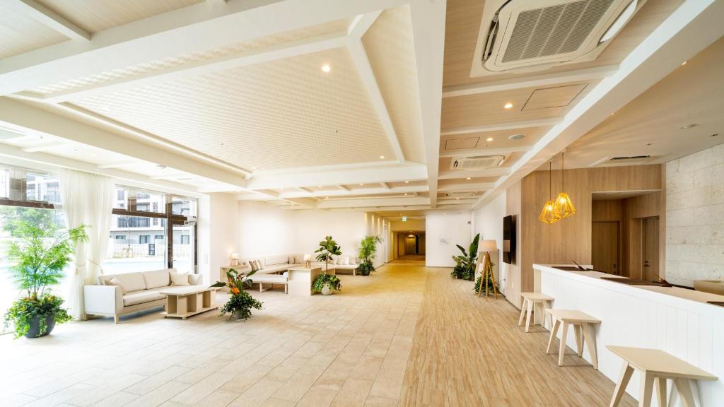 an office lobby with tables and chairs and plants at Hotel Torifito Miyakojima Resort in Miyako-jima