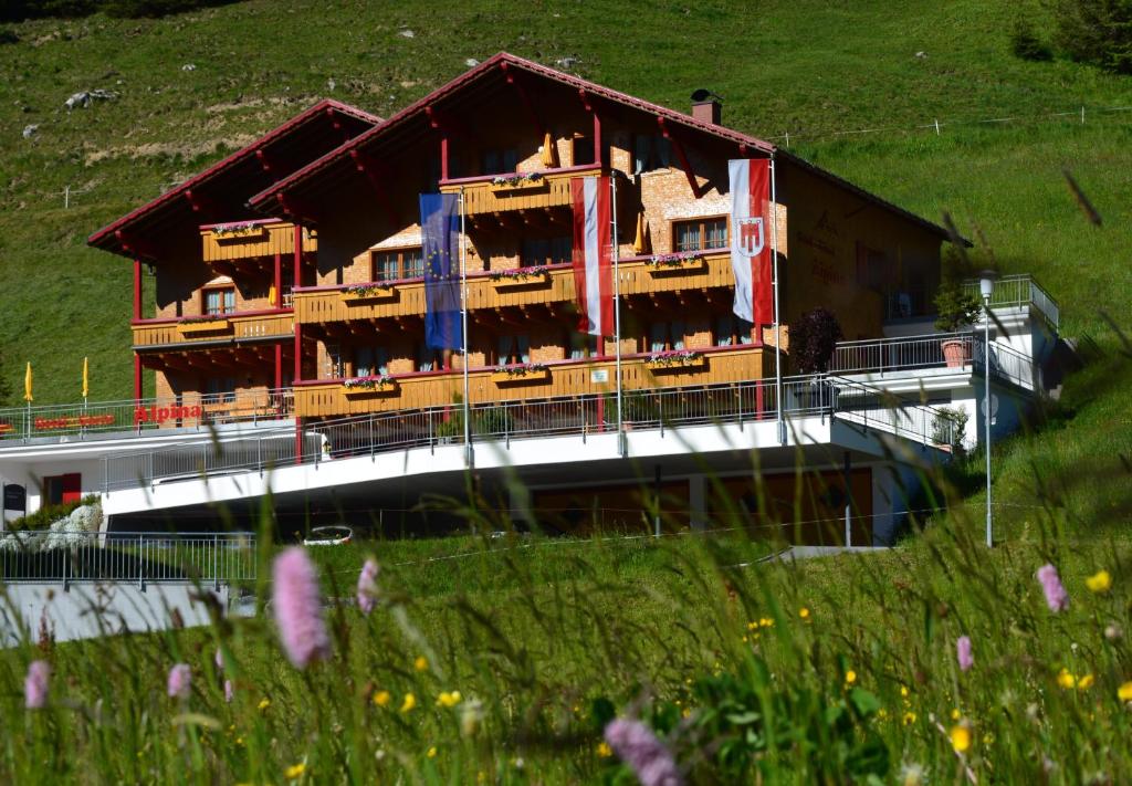 a train on a bridge in front of a building at Hotel Garni Alpina in Damuls